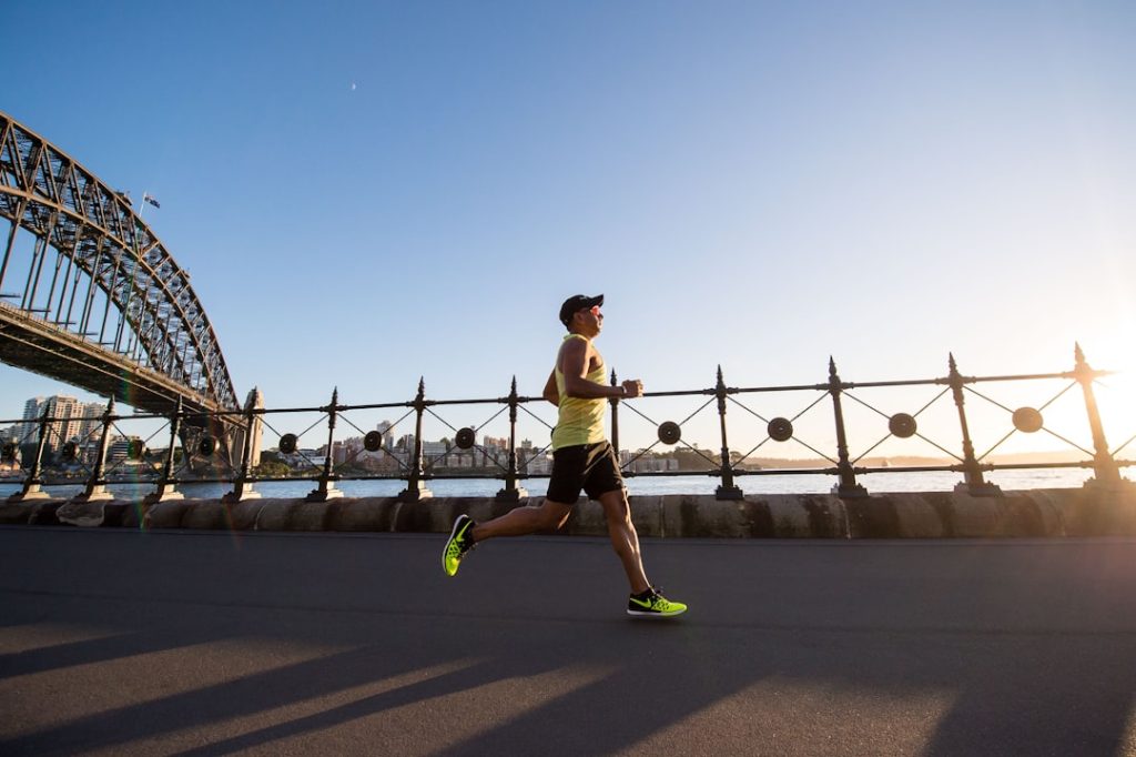 man-in-yellow-tank-top-running-near-shore-z4wh11fmfiq